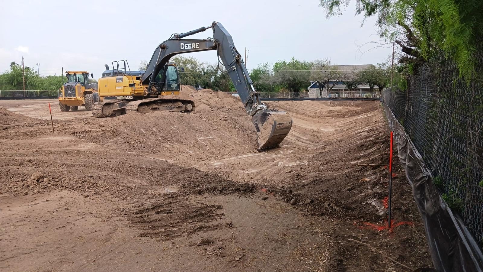 Excavator grading a drainage channel